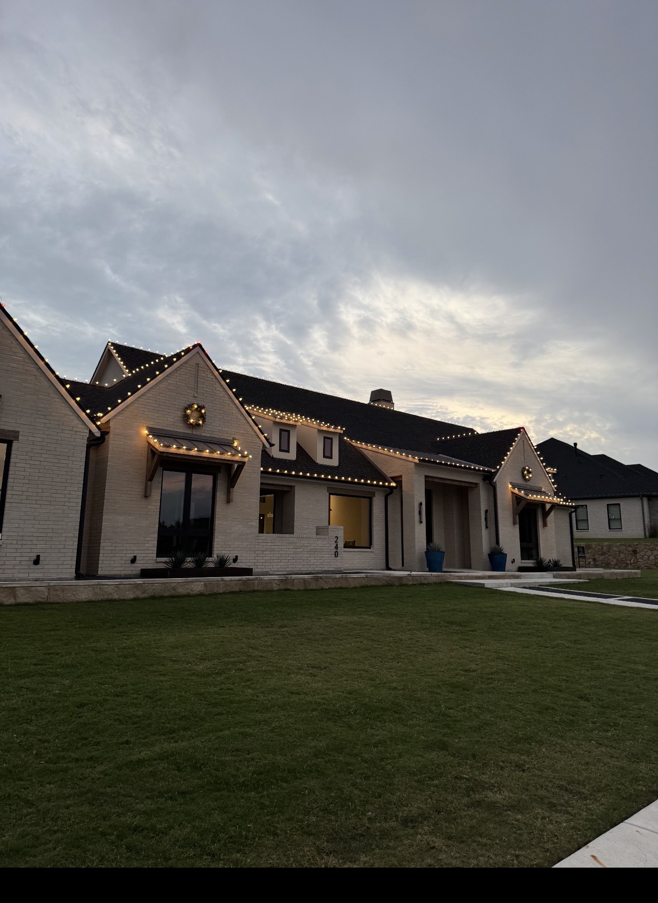 Warm white Christmas lights and wreaths on a residential home