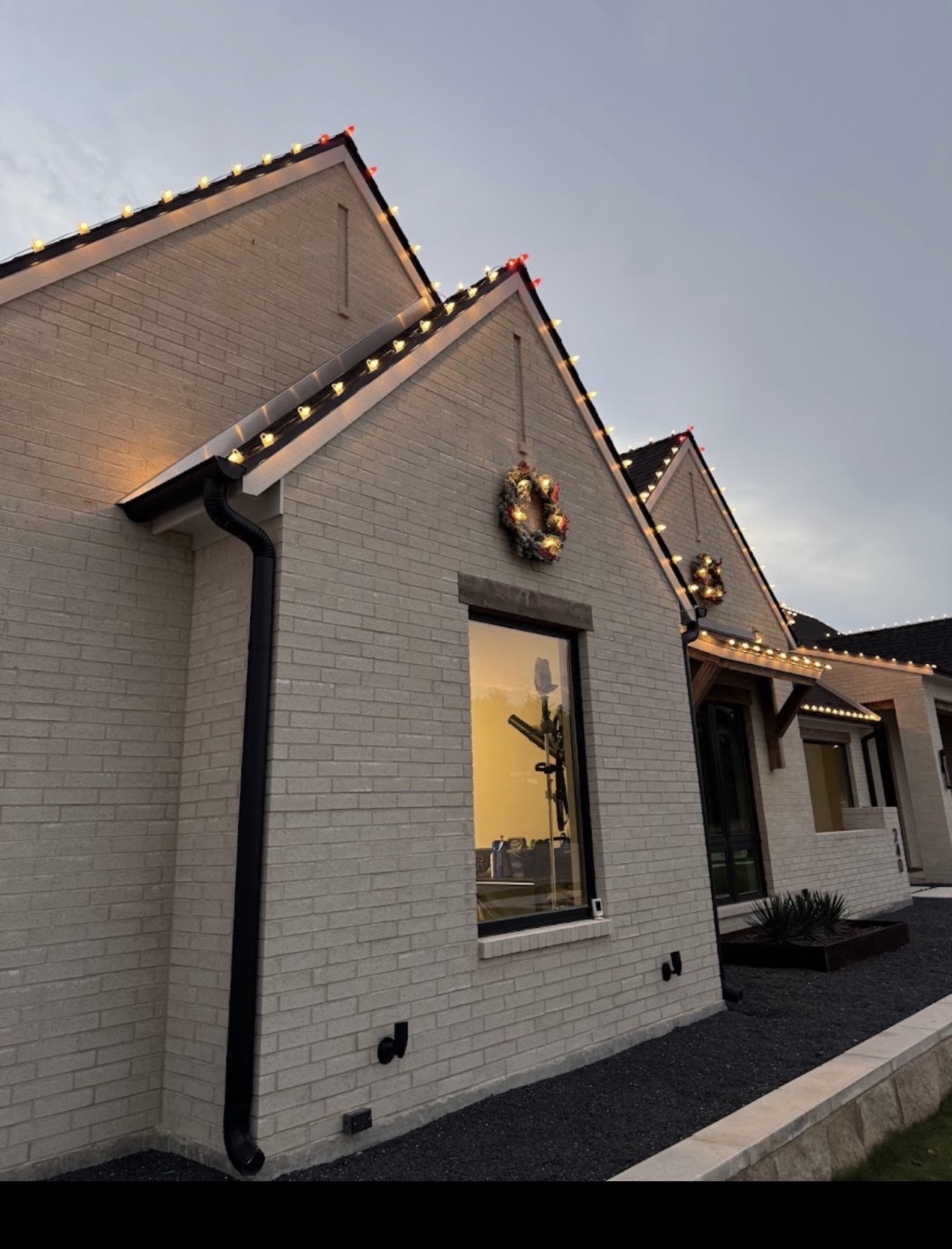 Close view of professionally installed warm white Christmas roofline lights